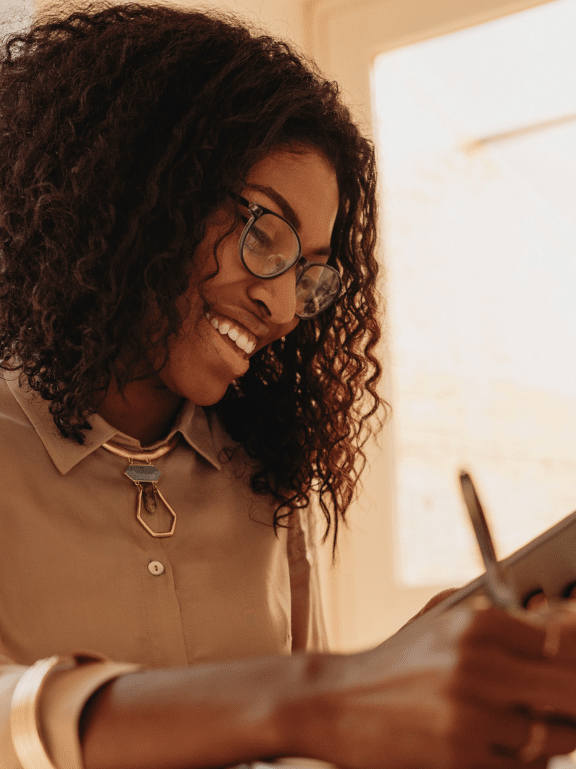 A businesswoman uses her online devices to learn EDI so her small business can fulfil its EDI mandate from its large trading partner.