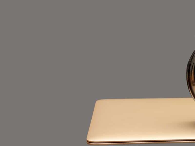 A cutout image of an alarm clock on top of a closed laptop, with a grey background colour. This shows how inefficiency in the finance department can be tackled with Automated accounts payable invoice processing