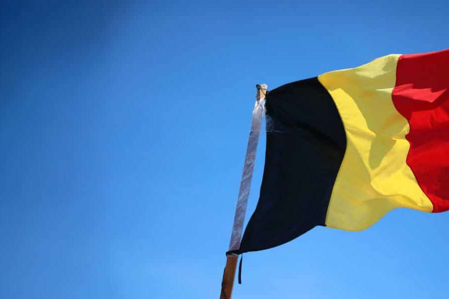 Photo of the Belgian flag flying in a blue sky. Used as a header image for the blog titled 