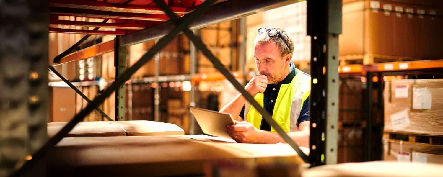 Blog-Headers Man reading ipad in warehouse