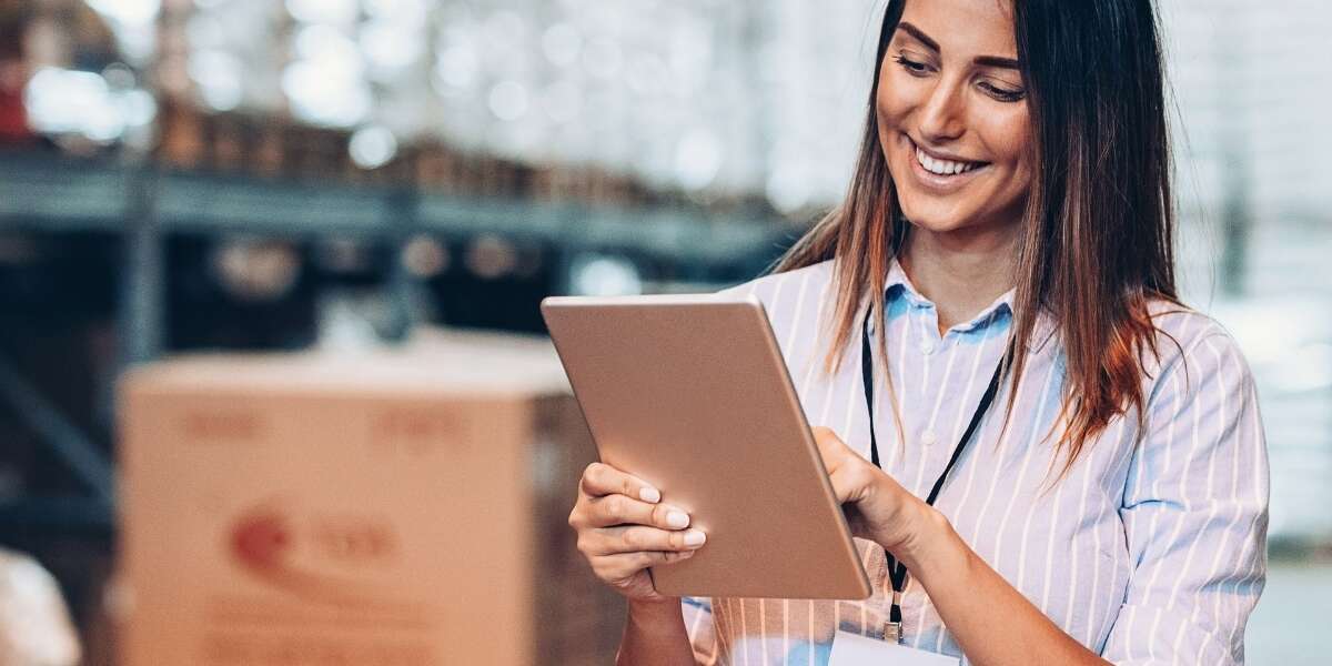 Stock photo of female warehouse manager with a tablet reviewing inventory levels. Representing blog post titled 