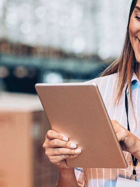 Stock photo of female warehouse manager with a tablet reviewing inventory levels. Representing blog post titled 