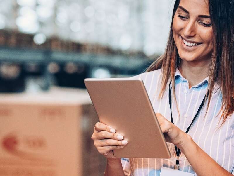 Stock photo of female warehouse manager with a tablet reviewing inventory levels. Representing blog post titled 