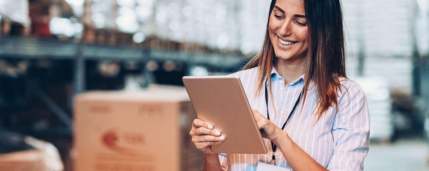 Stock photo of female warehouse manager with a tablet reviewing inventory levels. Representing blog post titled "Resilient supply chain strategy: Automated inventory tracking and localisation"