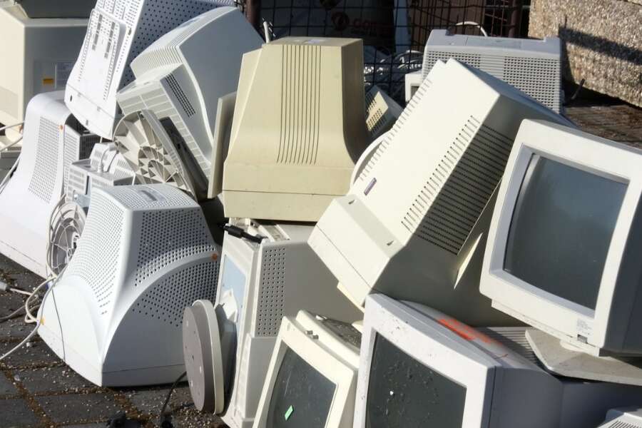 Piles of old, ugly and bulky desktop computers on a pavement. Representing Transalis blog post titled: How legacy EDI is holding you back