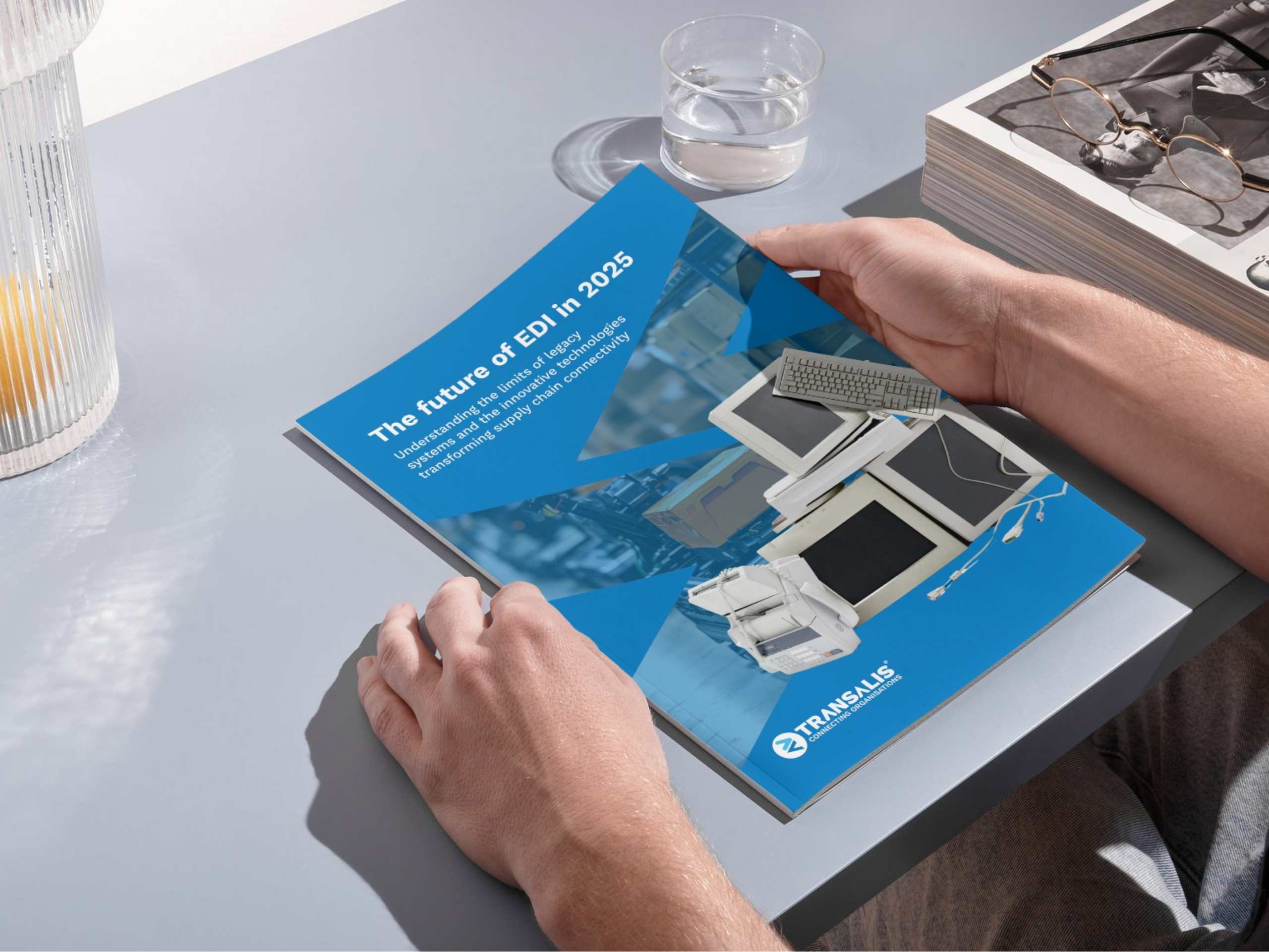 Mockup image of someone holding a booklet of the Future of EDI in 2025 report by Transalis